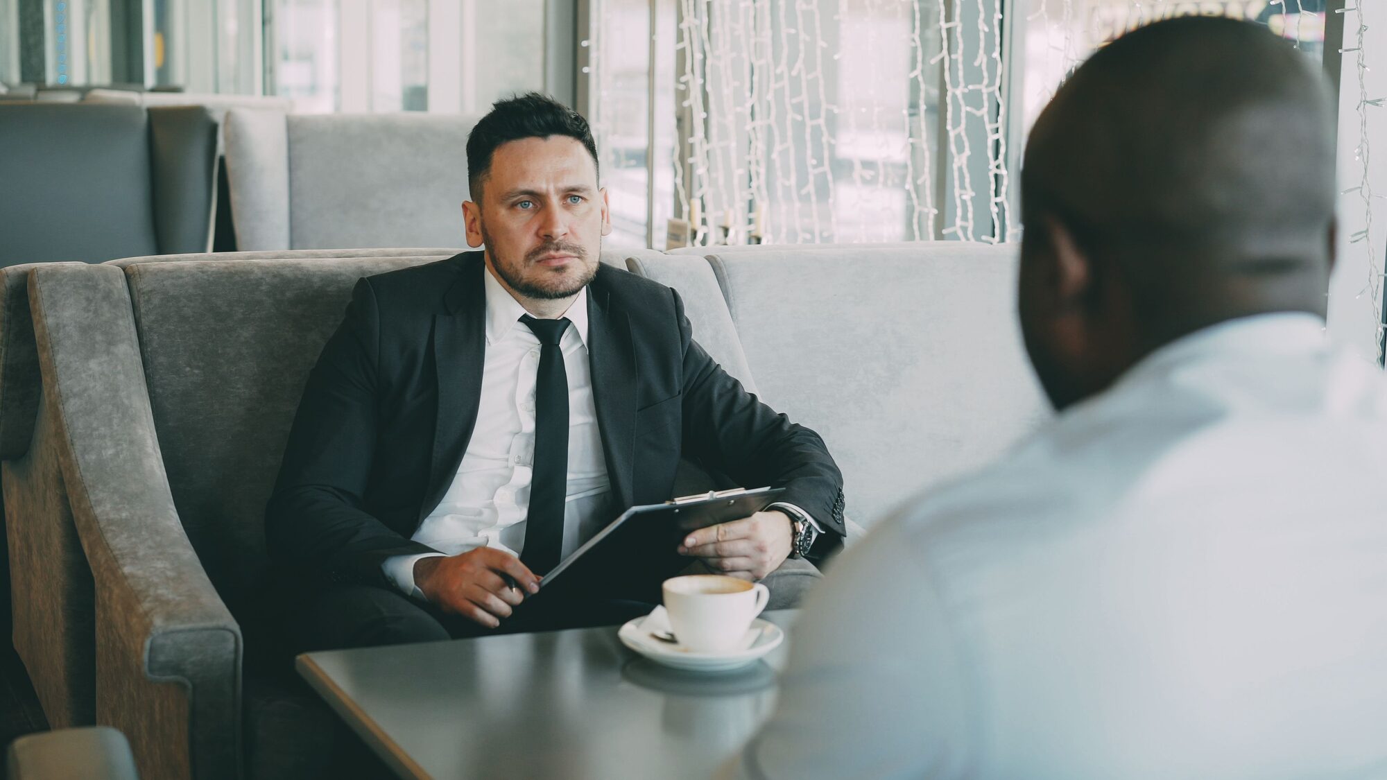 Consultant meeting with a client over coffee
