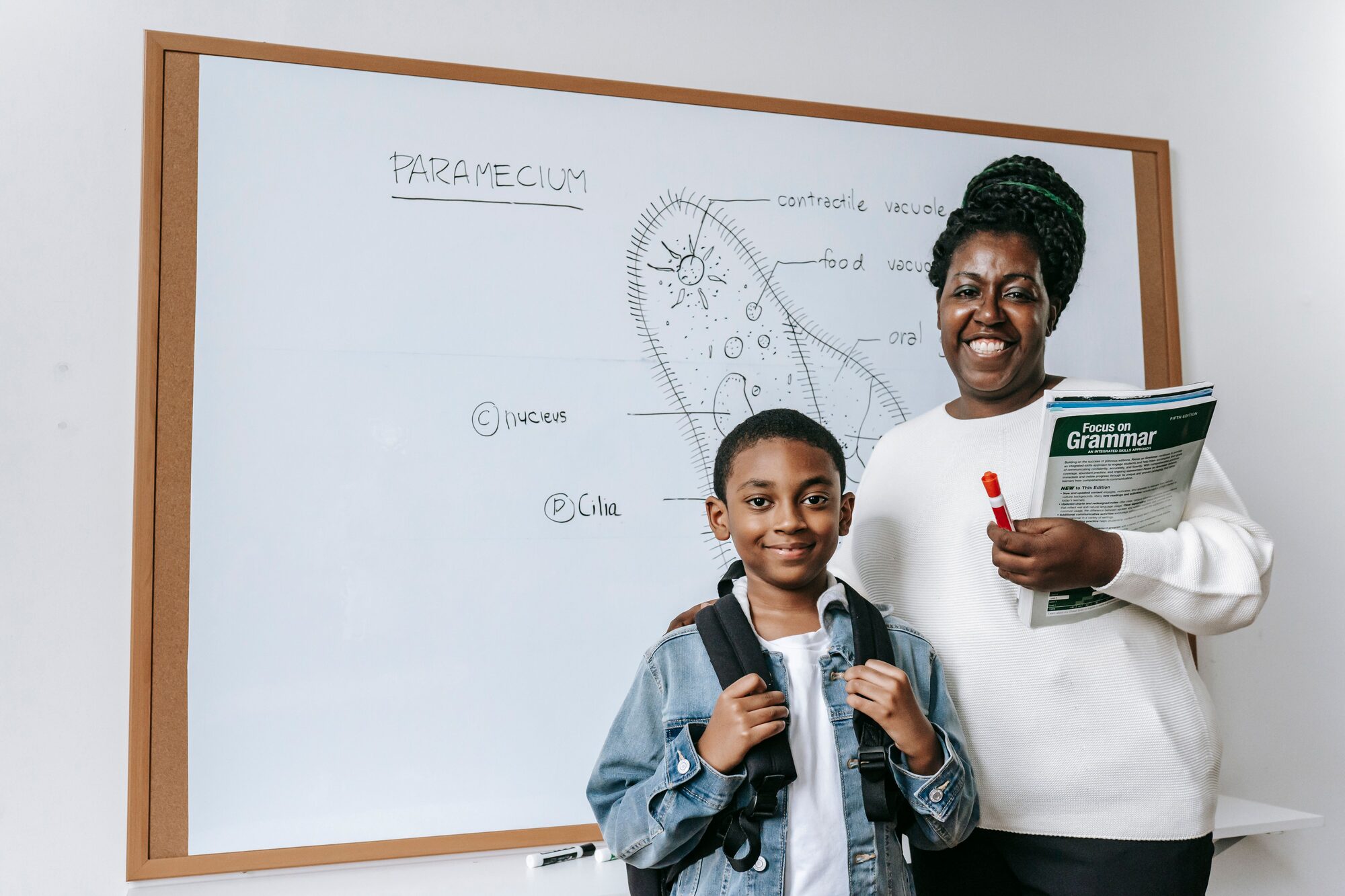 Tutor and student smiling in front of a lesson whiteboard